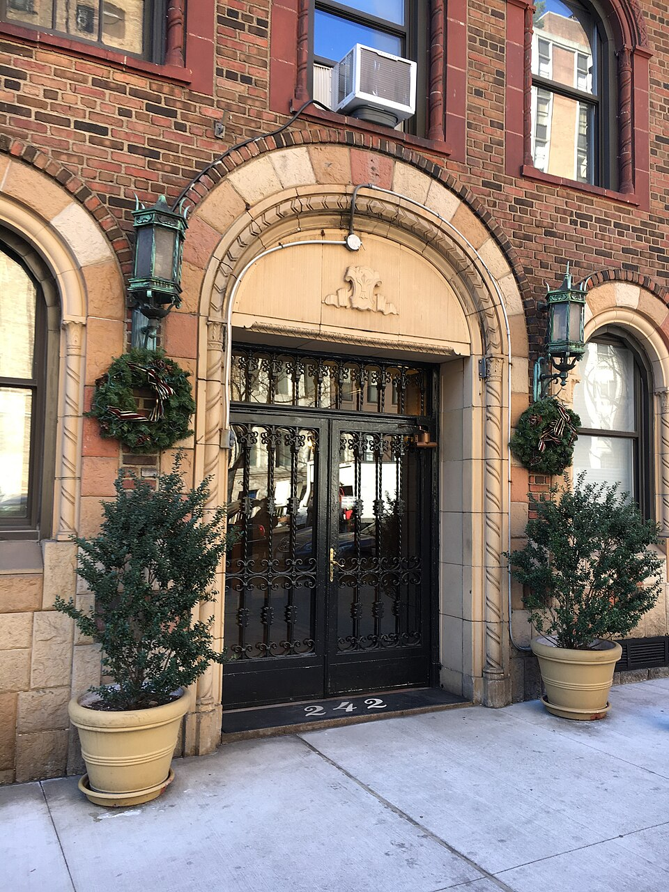 Urban office building with potted plants and arch doorway